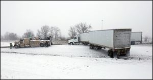 A tow truck prepares to right a jackknifed tuck on southbound I-75 near the I-280 split.