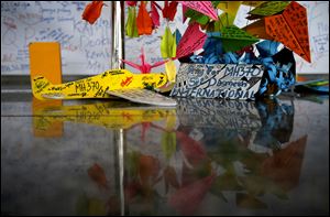 A foam plane with messages and other cards with personalized messages dedicated to people involved with the missing Malaysia Airlines jetliner MH370, is placed at the viewing gallery at Kuala Lumpur International Airport.