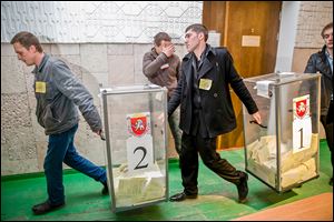 Referendum officials move boxes of paper ballots at a polling station after voting ended in Simferopol, Ukraine. The Crimeans’ vote, unrecognized both by the Ukrainian government and the West, was Sunday. 