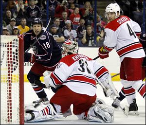 Carolina Hurricanes goalie Anton Khudobin (31), of Kazakhstan, and Andrej Sekera (4), of Slovakia, watch Columbus Blue Jackets' R.J. Umberger's shot go past the net.