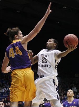 Mount St. Mary's guard Rashad Whack (22) drives against Albany center John Puk (44) during the first half.