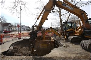 Construction workers continue to excavate a sink hole that opened up near the intersection of Fernwood Ave. near North Detroit Ave. in Toledo.