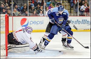 Brett Perlini takes a shot against Gwinnett goaltender Josh Unice, who is a St. John’s graduate, a Holland native, and a 2007 third-round draft pick of Chicago.