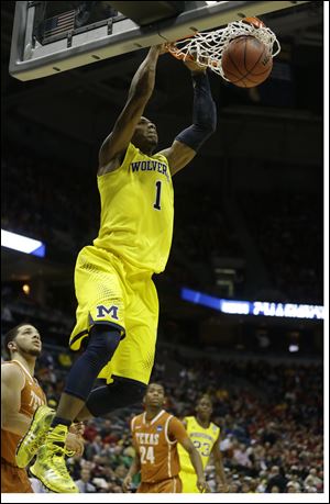 Michigan forward Glenn Robinson III (1) dunks during the first half of a third-round game against the Texas.