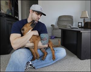 Titan, called Pupsicle when it was rescued from a cold doorstep, licks its new owner Michael Kurdziel, Jr., in his Toledo home.