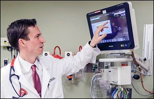 Dr. Marcus Romanello, medical director for the Fort Hamilton Hospital emergency room, checks equipment in the emergency room of the hospital in Hamilton, Ohio.