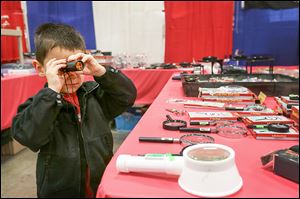 Samuel Wise, 4, of Whitehouse takes a closer look at model-crafting tools as he and his father, Brian, walk through the vendors’ stalls during Sunday’s expo.