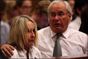 Mother of the late Reeva Steenkamp, June Steenkamp, left, is comforted by family lawyer Dup de Bruyn, as they listen to cross questioning of Oscar Pistorius, in court in Pretoria, South Africa, today.