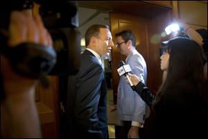 Australian Prime Minister Tony Abbott, center, is questioned by a Chinese TV reporter about the missing Malaysian Airlines Flight 370 after a press conference today at a hotel in Beijing, China.