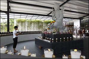 A Buddhist devotee holds a candle while offering prayers for passengers onboard the missing Malaysia Airlines Flight 370 at Kechara Forest Retreat in Bentong, outside Kuala Lumpur, Malaysia, today.