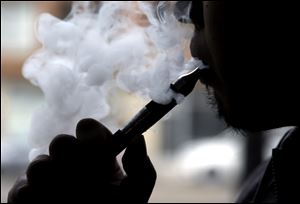 Daryl Cura demonstrates an e-cigarette at Vape store in Chicago, Wednesday.