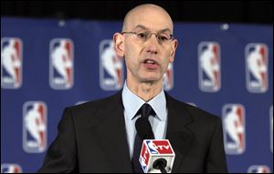 NBA Commissioner Adam Silver reads a statement during a news conference, in New York, today, announcing that he is banning Los Angeles Clipper owner Donald Sterling for life from the Clippers organization, in response to racist comments the league says he made in an audio recording.