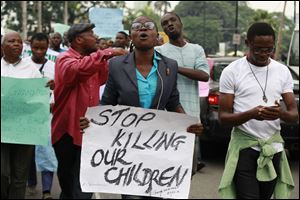 People attend a demonstration calling on  government to rescue kidnapped school girls of a government secondary school Chibok, during workers day celebration in Lagos, Nigeria Thursday.