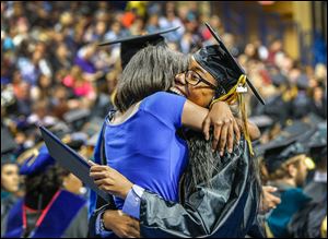 Joslin Smith, 15, and a student at Whitmer High School, congratulates her sister, Cortney Carney, right, also of Toledo, as she receives her bachelor’s degree in social work.