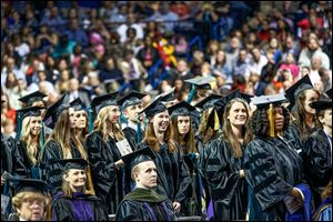 Doctoral candidates rise during spring commencement exercises at the University of Toledo. This month, UT graduated 124 with doctoral, 1,941 with bachelor’s, and 554 with master’s degrees.