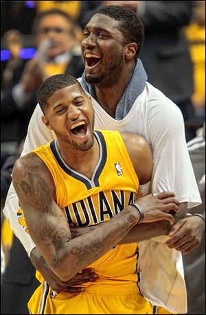 The Pacers’ Paul George, front, and Roy Hibbert react to a basket on Saturday. George scored 30 points to help Indiana win Game 7.