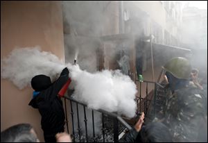 A pro-Russian protester fires a fire extinguisher at riot police inside at a police station building today in Odessa, Ukraine.