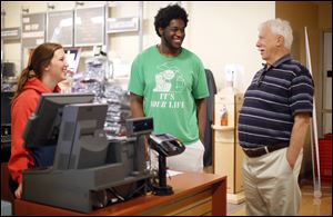 Dick Larabee, 79, talks with Ron Freeman, a junior at Bowling Green State University, at the campus bookstore. Mr. Larabee, who lives in Waterville, will receive a bachelor’s degree in liberal studies during spring commencement ceremonies.