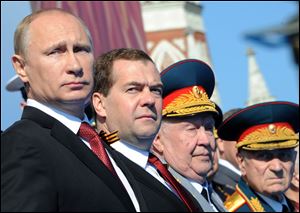 Russian President Vladimir Putin, left, and Prime Minister Dmitry Medvedev attend a Victory Day parade, which commemorates the 1945 defeat of Nazi Germany, at Red Square in Moscow, Russia, today.