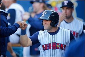 Toledo Mud Hens player Tyler Collins  is greeted in the dugout after scoring on a hit by James McCann.