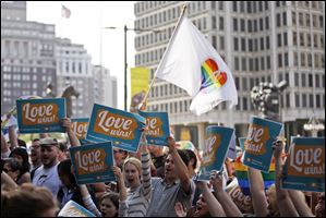 People hold up signs and cheer during a rally at City Hall, Tuesday in Philadelphia. Pennsylvania's ban on gay marriage was overturned by a federal judge Tuesday. 