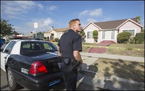 A police officer stands guard in front of the home of actor Michael Jace on today in Los Angeles. April Jace, 40, was found dead inside, officials said. Mr. Jace was taken into custody and booked early today on suspicion of homicide. He was being held in a Los Angeles jail in lieu of $1 million bail.