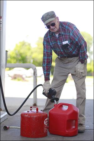 Ray Elieff fills up gas cans in preparation for how he will spend his Memorial Day weekend: cutting his grass. 