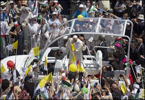 Pope Francis greets people as he arrives today to the West Bank town of Bethlehem.