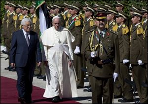 Palestinian President Mahmoud Abbas, left, and Pope Francis inspect an honor guard as Francis arrives at the Palestinian Authority headquarters.