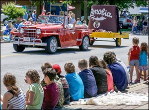 Children line the curb as the Zenobia Shrine hat rolls by down Summit Street in the annual parade. 