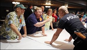 Dennis Lange argues with security personnel before he was thrown out of the Lucas County Republican Party Central Committee meeting at The Premier in South Toledo on Wednesday.