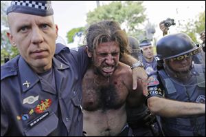 A protester is detained by police during a demonstration demanding better public services and protesting the money spent on the World Cup soccer tournament in Sao Paulo.