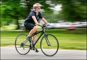  Katie Rupert, who will be a cyclist in the National Special Olympics, rides her bike at the City Park in Bowling Green.