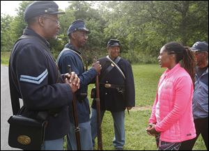 Lee Randles, left, and Clark Morgan, both of Holland, and Jim Proctor of Toledo speak with Juneteenth chairman Arnyka Harris of Toledo in Swan Creek Metropark. 