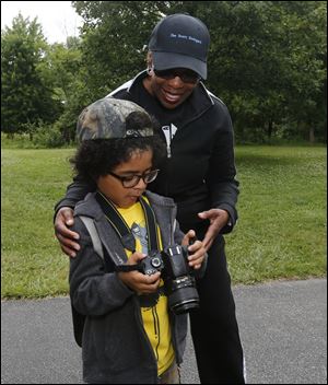 Ajani  Hammack, 7, left, shows Patricia Hogue some of the photos he took during the events. 