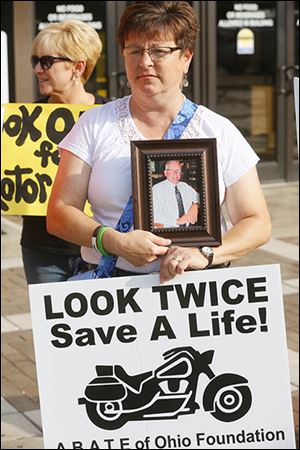 Mary Bobinski, sister-in-law of Lawrence J. Hilton, 54, of Swanton,  who was killed on his motorcycle at Dorr Street and Richards Road, holds Mr. Hilton’s picture during a protest outside of Toledo Municipal Court before the bench trial of Dr. Nabil Ebraheim, 63, for vehicular manslaughter.