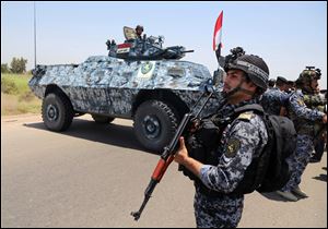 Iraqi federal policemen patrol in Baghdad's Abu Ghraib suburb, Iraq, Saturday, June 28, 2014. Iraqi troops backed by helicopter gunships launched an operation early Saturday aimed at dislodging Sunni militants from the northern city of Tikrit, one of two major urban centers they seized in recent weeks in a dramatic blitz across the country.