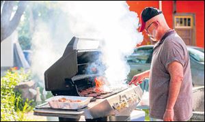 Greg Peters, Toledo flips burgers during the LifeLine Community Dinner at the home of Stephanie and Shawn Parker-Kellerbauer.