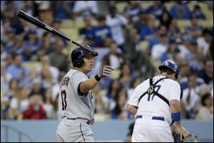 Cleveland Indians' Asdrubal Cabrera, left, tosses his bat after striking out as Los Angeles Dodgers catcher A.J. Ellis heads to the dugout during the third inning,