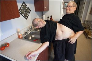 Donnie, left, and Ronnie Galyon, 62, walk to get water inside their Beavercreek, Ohio, home.