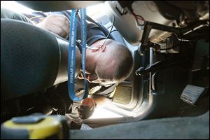 Sgt. Doug Baker searches a vehicle for drugs during an enforcement sweep in Northwood that included Oregon and Perrysburg Township police departments and the Wood County Sheriff’s Office.  