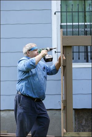 Jonah Sowards drills a panel to make a cover for his air conditioner at his home at 2915 E St. His property was noted as an example of pride in ownership.