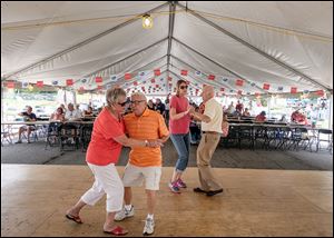 Richard and Mary Ann Jankowski, left, of Toledo dance, as do Sarah Meyers of Ridgeville Corners and Ray Racey of Temperance, Mich., on Saturday during the Lagrange Street Polish Festival. Polish American Concert Band, Duane Malinowski Band, and Kuszwanc Kids Band are all scheduled to perform at the festival today.