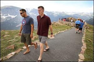 Visitors walk a short trail at a scenic overlook off Trail Ridge Road, above tree-line at Rocky Mountain National Park, west of Estes Park, Colo., Monday, July 14, 2014. Lightning killed two people last weekend just miles apart in the popular park.