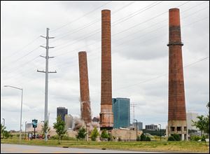 The view from the base as the first of two smokestacks is imploded.