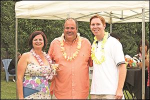 Northwest Ohio Community Shares event chairman Dawn Christen, left, with auctioneer Jack Amlin, and event emcee Shaun Hegarty enjoy the tropical party.