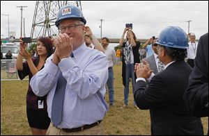 Mayor D. Michael Collins applauds at the site. The mayor, state Rep. Teresa Fedor, and Bill Buckley of the Great Lakes museum pushed the ceremonial plunger.