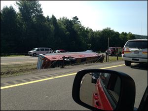 A Canadian tour bus carrying 54 people from Quebec City to New York City rests on its side after rolling over Friday on the Northway in the Adirondacks in Essex County, N.Y.