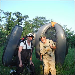 Lee Woldenberg of Perrysburg, right, and his son, Matt, carry float tubes in the secluded strip mine lakes of southeastern Ohio. They fished for bass with  guide Corneilus Harris of Zanesville.