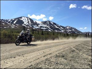 Chris Day churns up dust on the Denali Highway of Alaska during an 865-mile ride around Alaska with seven of his friends.